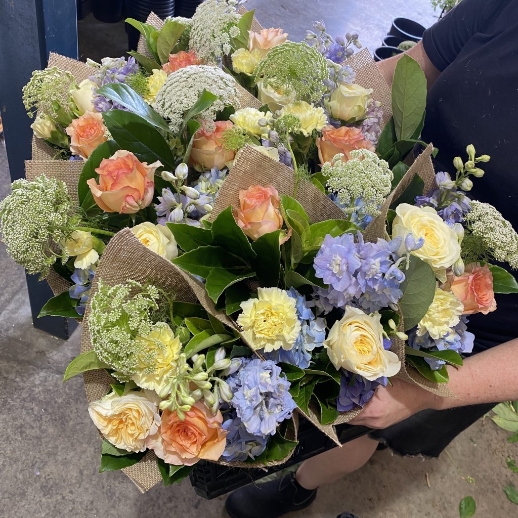 Box of multiple flower bunches prepared for corporate delivery