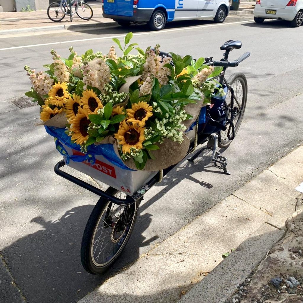 Bike with a basket packed full of flowers ready for delivery