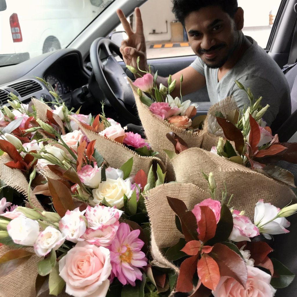 Delivery driver loading van with flower orders